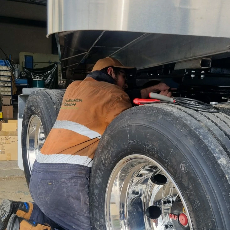 Technician installing automatic lubrication system